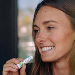 Woman applying Badger Highland Mint Lip Balm