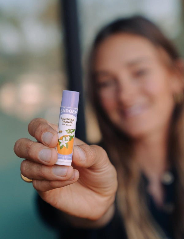 Badger Lavender and Orange Lip Balm held in hand