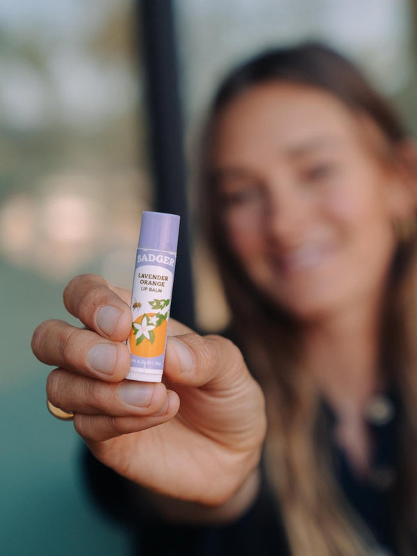 Badger Lavender and Orange Lip Balm held in hand