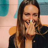 Woman applying Badger Pink Grapefruit Lip Balm