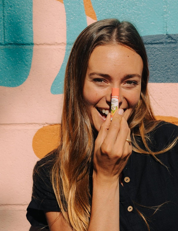 Woman applying Badger Pink Grapefruit Lip Balm