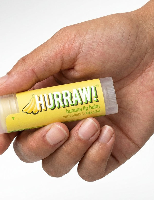 Hand holding Hurraw! Organic Lip Balm - Banana with Baobab 4.8g