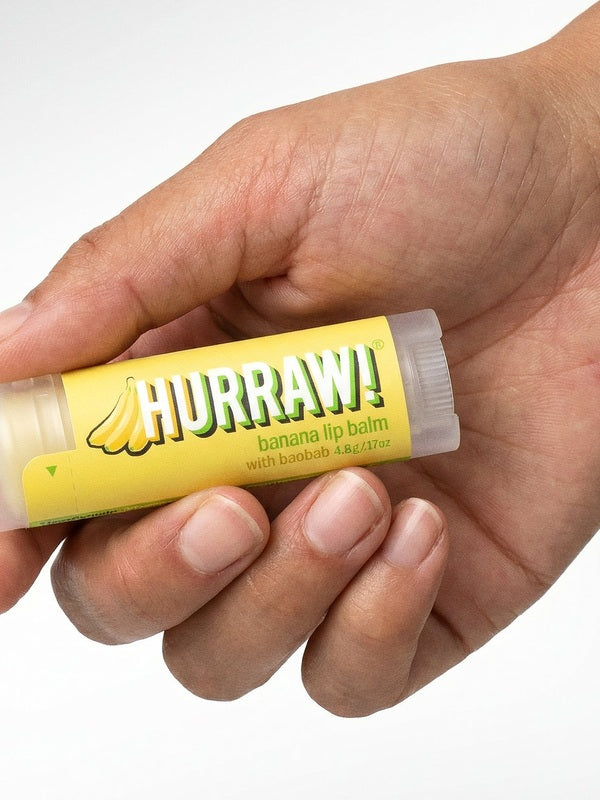 Hand holding Hurraw! Organic Lip Balm - Banana with Baobab 4.8g
