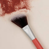 Benecos Blush Brush arranged diagonally across crushed warm red blush pigment.