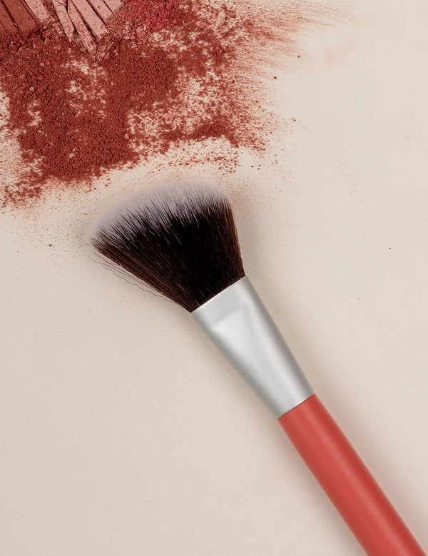 Benecos Blush Brush arranged diagonally across crushed warm red blush pigment.