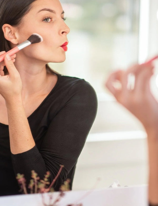 Model applying blush with a brush for Benecos Beauty ID Palette Blush Refill in Tuscany Please.