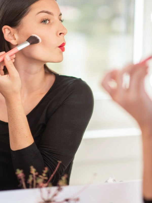 Model applying blush with a brush for Benecos Beauty ID Palette Blush Refill in Tuscany Please.