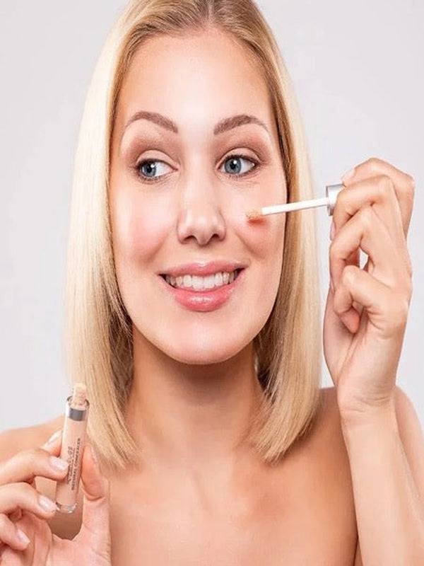 Model applying Benecos Concealer beneath her eye with the doe-foot applicator.