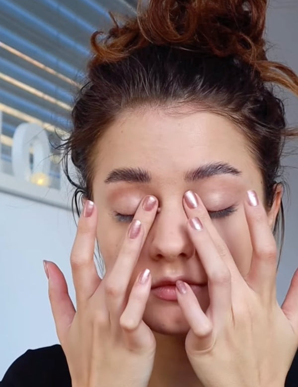 Model gently applying Benecos Prime Fine Eye Shadow Primer to both eyelids with her fingertips.