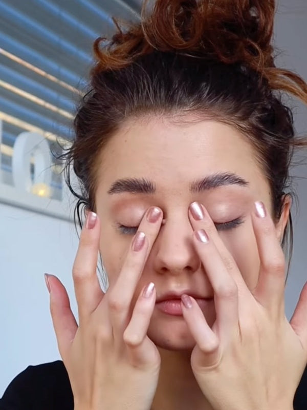 Model gently applying Benecos Prime Fine Eye Shadow Primer to both eyelids with her fingertips.