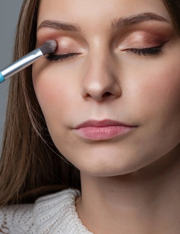 Model applying warm neutral eyeshadow with the Benecos Eyeshadow Brush.