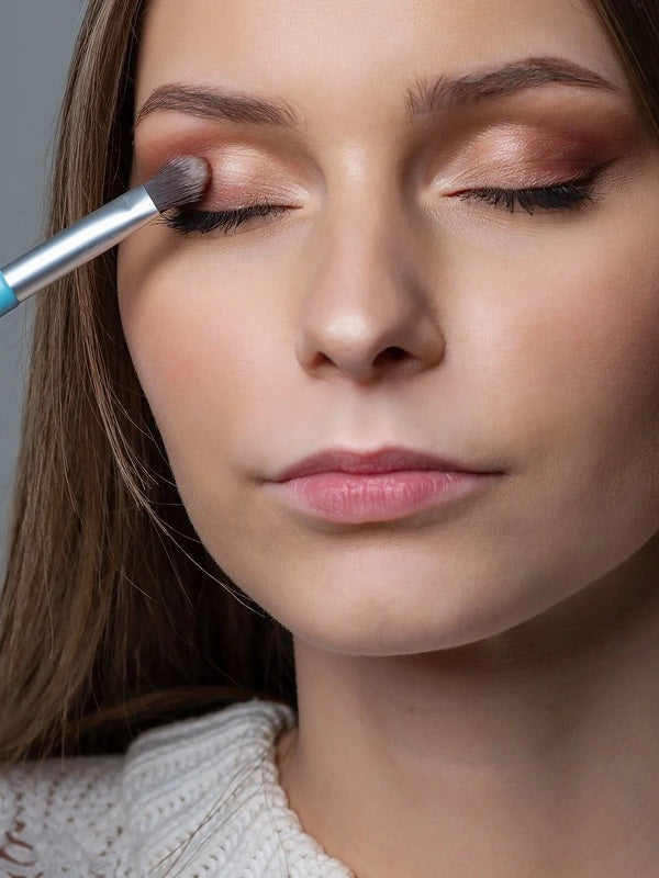 Model applying warm neutral eyeshadow with the Benecos Eyeshadow Brush.
