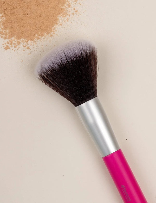 Benecos Powder Brush arranged diagonally beside loose beige powder on a cream background.