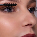Close-up of a model applying Benecos Super Long Lashes Mascara in Carbon Black to her upper lashes.