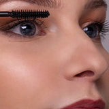Close-up of a model applying Benecos Super Long Lashes Mascara in Carbon Black to her upper lashes.