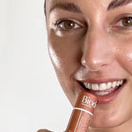 Model applying Biode Lip & Cheek Tinted Balm in Copper Daisy directly to her lips.