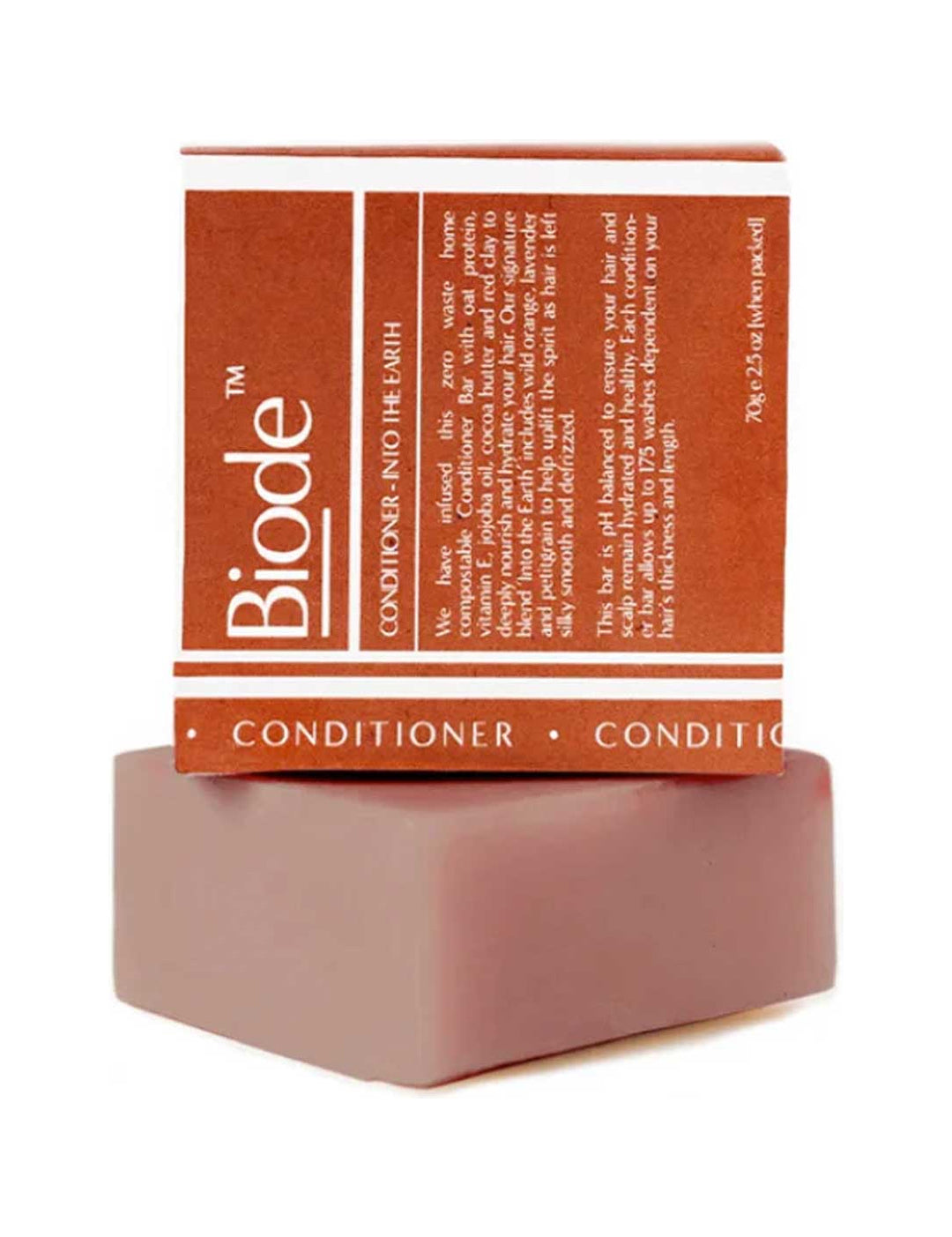 Dusty pink rectangular Biode Into the Earth conditioner bar beneath a terracotta carton printed with white lines and lettering.