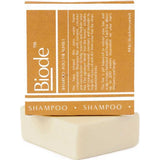 Cream-coloured rectangular Biode Into the Sunset shampoo bar beneath a mustard yellow carton printed with white lines and lettering.