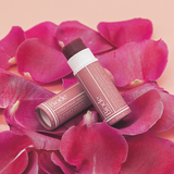 Biode Lilly Pilly Tinted Lip Balm styled with rose petals