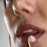 Close-up of a model applying Biode Lip & Cheek Tinted Balm in Waratah to her lips.