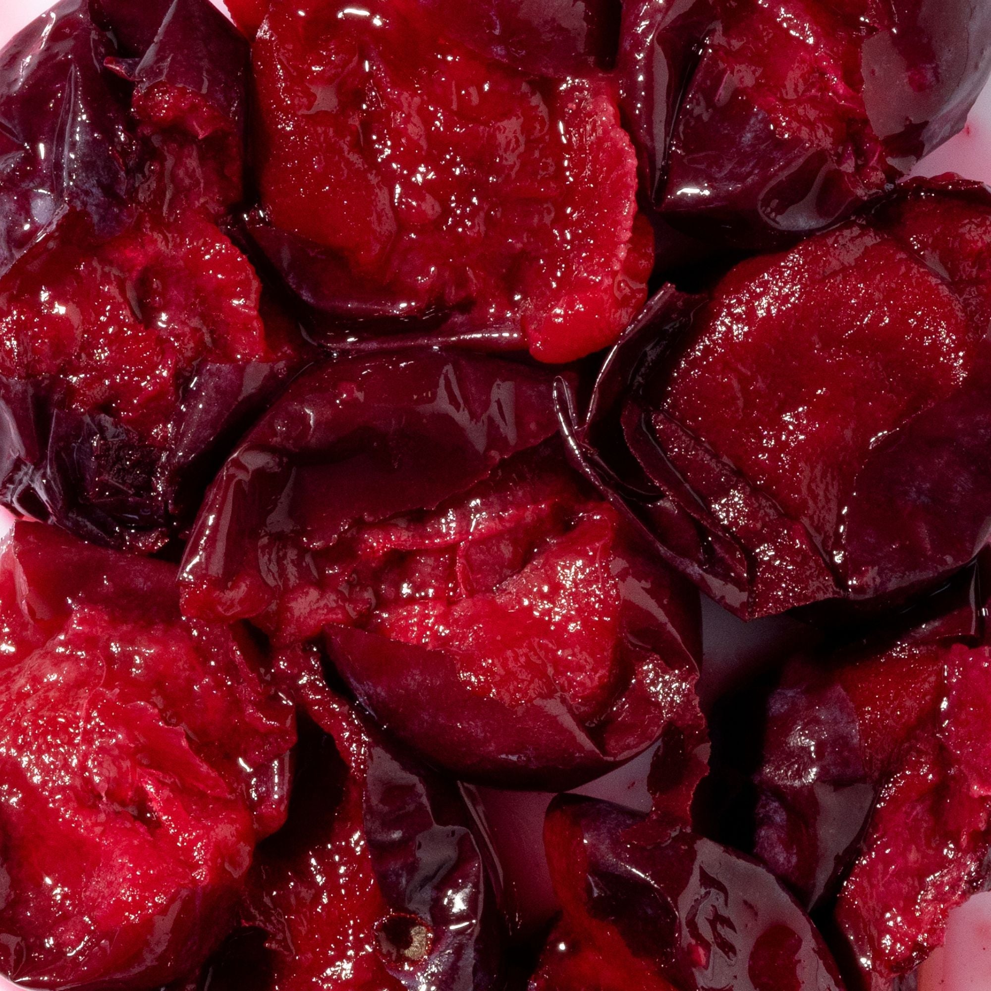 Close-up of deep red and purple chopped Davidson plum fruit, the botanical ingredient in Biologi Bd Luminosity Face Serum.