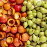 Quandong fruit with exposed stones arranged beside green Kakadu plums, showing the two botanical ingredients featured in Biologi Bqk Radiance Face Serum Duo.