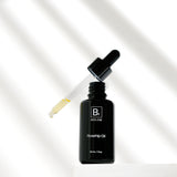 An open Biologi Br Rosehip Oil bottle stands on a white block beneath its raised glass dropper containing pale yellow oil, with soft diagonal shadows.