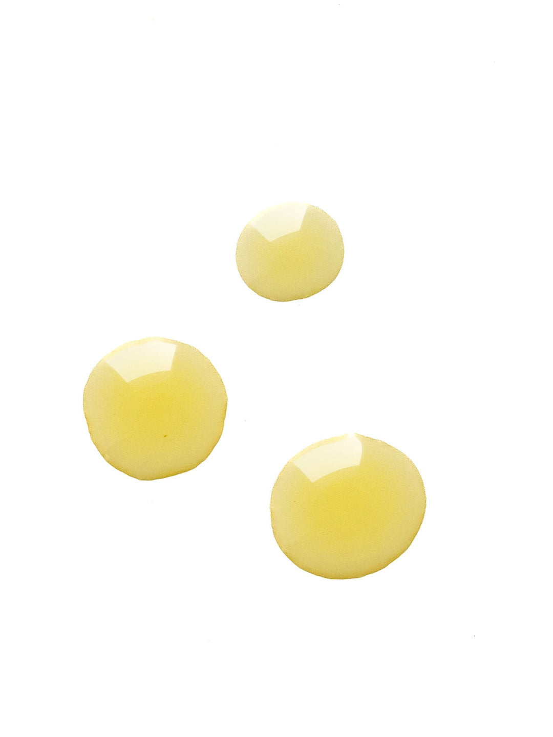 Three glossy pale yellow drops of Biologi Br Rosehip Oil on white, showing the oil's colour and fluid texture.