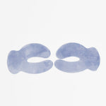 Two lavender-blue Biologi Revive Bio Cellulose Eye Mask patches laid flat on white, showing their curved shape, eye openings and woven texture.