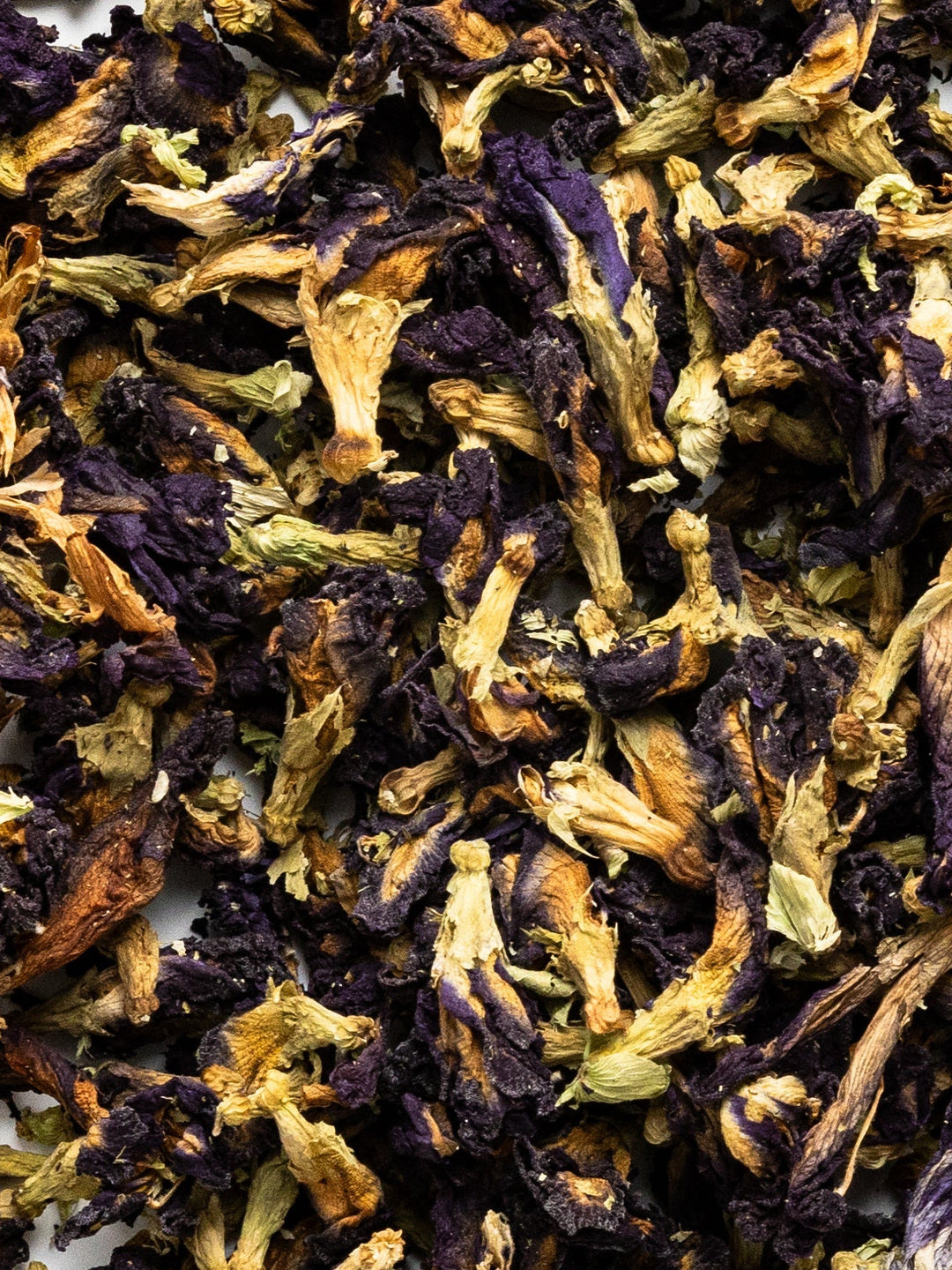 Close-up of dried blue-purple butterfly pea flowers mixed with pale stems, the botanical ingredient featured in Biologi Revive Bio Cellulose Eye Mask.