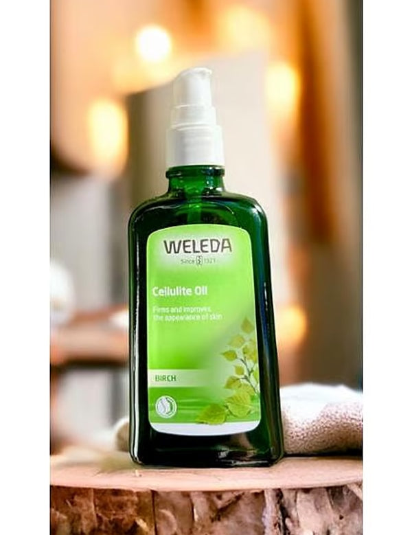Weleda Birch Cellulite Oil bottle on a natural wooden surface