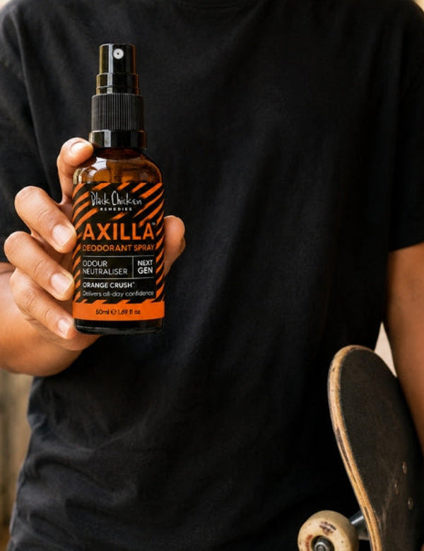 Black Chicken Remedies Axilla Orange Crush Deodorant Spray — held in hand