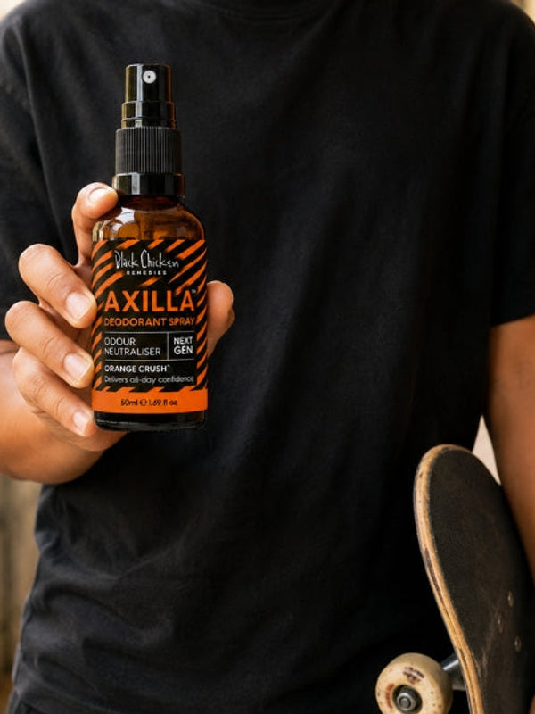 Black Chicken Remedies Axilla Orange Crush Deodorant Spray — held in hand