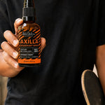 Black Chicken Remedies Axilla Orange Crush Deodorant Spray — held in hand