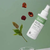 White Botani Rescue Pore Refiner Essence bottle suspended diagonally above a glass beaker, with green leaves and dried red berries against a sage-green background.