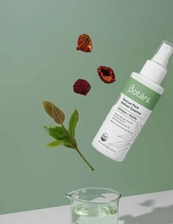 White Botani Rescue Pore Refiner Essence bottle suspended diagonally above a glass beaker, with green leaves and dried red berries against a sage-green background.