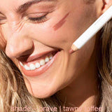 Woman applying makeup with a pencil, close-up of face.