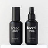 Two black Breed Daisy Dog Pup Perfume bottles displayed upright on a white plinth.