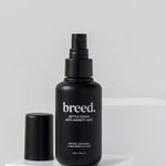Breed Settle Down Anti-Anxiety Mist bottle and cap displayed on white studio plinths.
