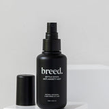 Breed Settle Down Anti-Anxiety Mist bottle and cap displayed on white studio plinths.