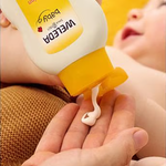 Weleda Calendula Body Lotion being dispensed before application to a baby.