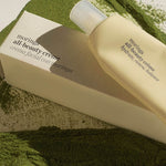 Ere Perez Moringa All-Beauty Creme tube and box resting on green moringa powder