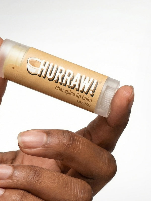 Hand holding Hurraw! Organic Lip Balm - Chai Spice 4.8g
