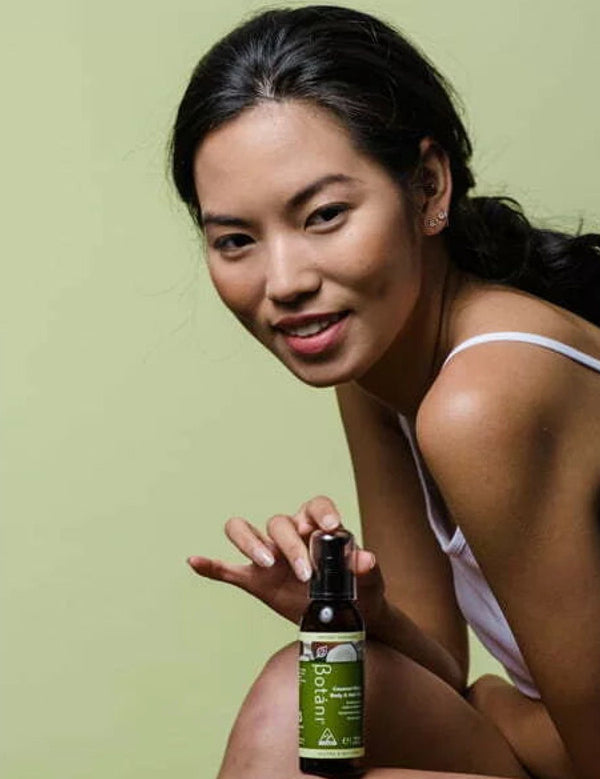 Botani Coconut Glow Body & Hair Oil 125ml — model holding body and hair oil