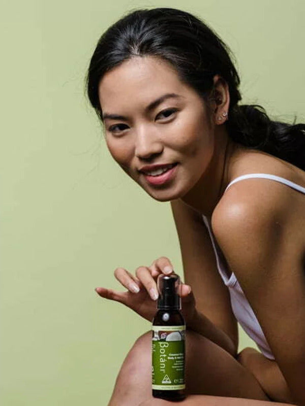 Botani Coconut Glow Body & Hair Oil 125ml — model holding body and hair oil