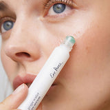 Young woman rolling Ere Perez Grape Water Eye Serum onto the skin under her eye