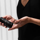 Woman in a black dress holding the Mukti Botanique Natural Deodorant Sandalwood and Sage