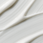 Extreme close-up of glossy white cream swept diagonally into smooth folds and narrow raised ridges.