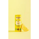 Deodorant Stick Citrus-Bergamot next to a slice of lemon, against yellow background.