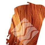 Close-up of bright copper-orange hair for Desert Shadow Copper Shadow, cropped into an irregular brushstroke shape with the brand's pale geometric logo overlaid.